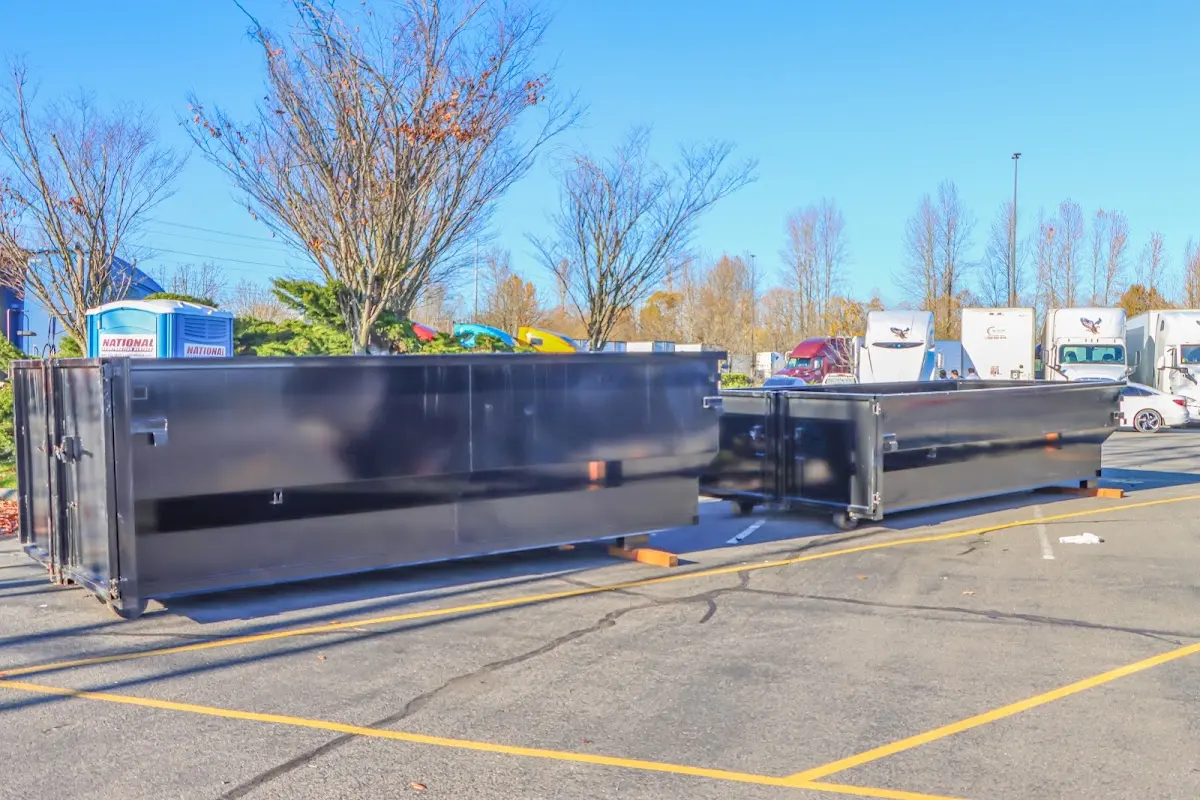 Professional dumpster rental service with roll-off container on residential driveway in Versailles